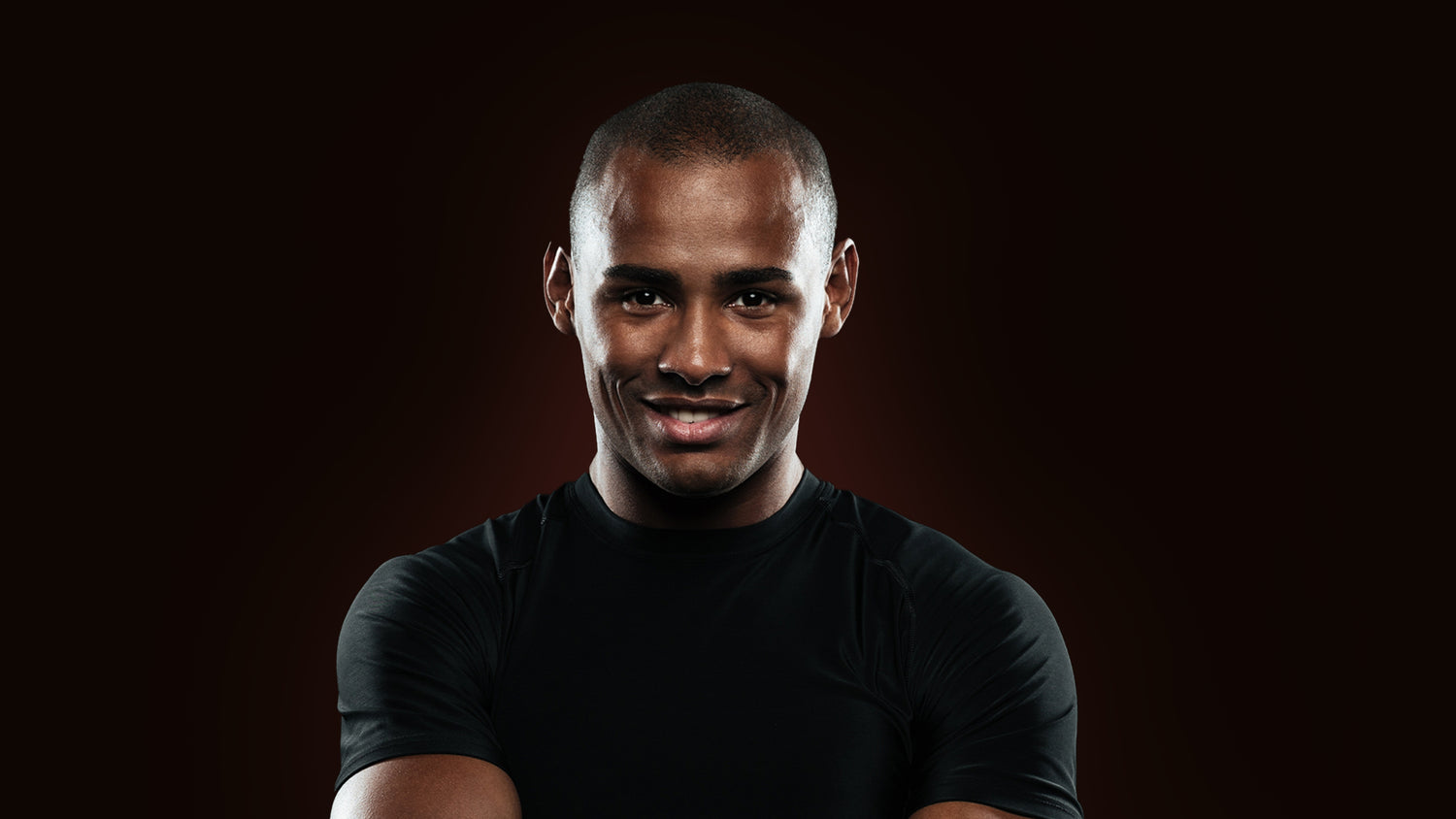 A Black background image of a Happy Confident Man wearing a back T-shirt.